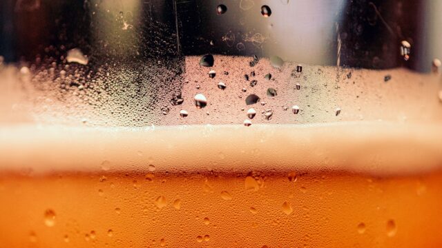 グラスに注がれたビールの泡と結露のクローズアップ