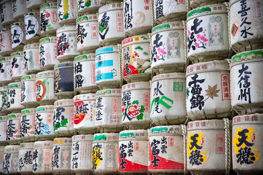 神社に奉納された色とりどりの菰樽(こもだる)が積み重なった壁。各蔵元の銘柄名が書かれたラベルが並んでいる