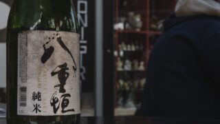 日本語のラベルが貼られた日本酒の瓶がテーブルに置かれている