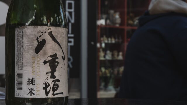 日本語のラベルが貼られた日本酒の瓶がテーブルに置かれている