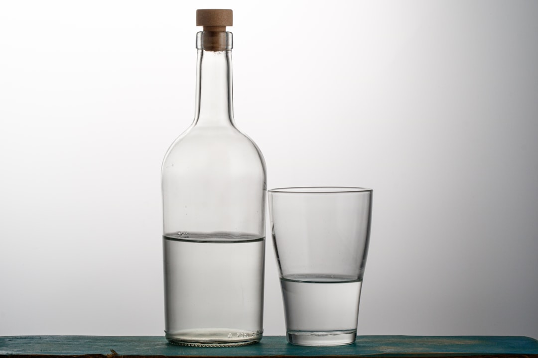 透明な瓶とグラスに注がれた透明な酒