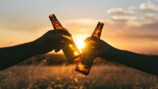 夏の太陽の下で冷たいビールを楽しむイメージ
