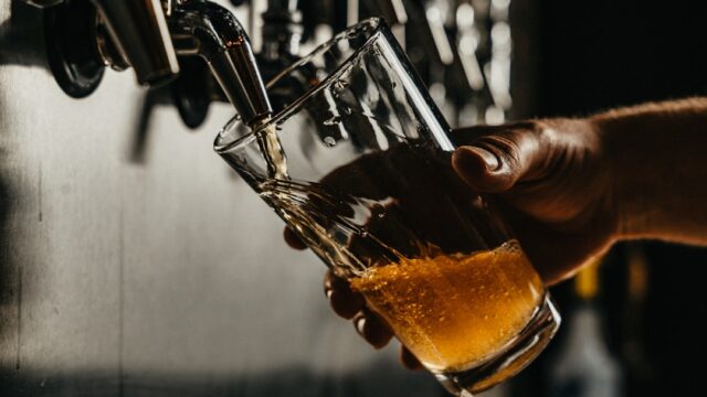 ビールサーバーからグラスにビールを注ぎ、泡が立っている様子