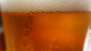 グラスに注がれたビールの泡と液面のクローズアップ