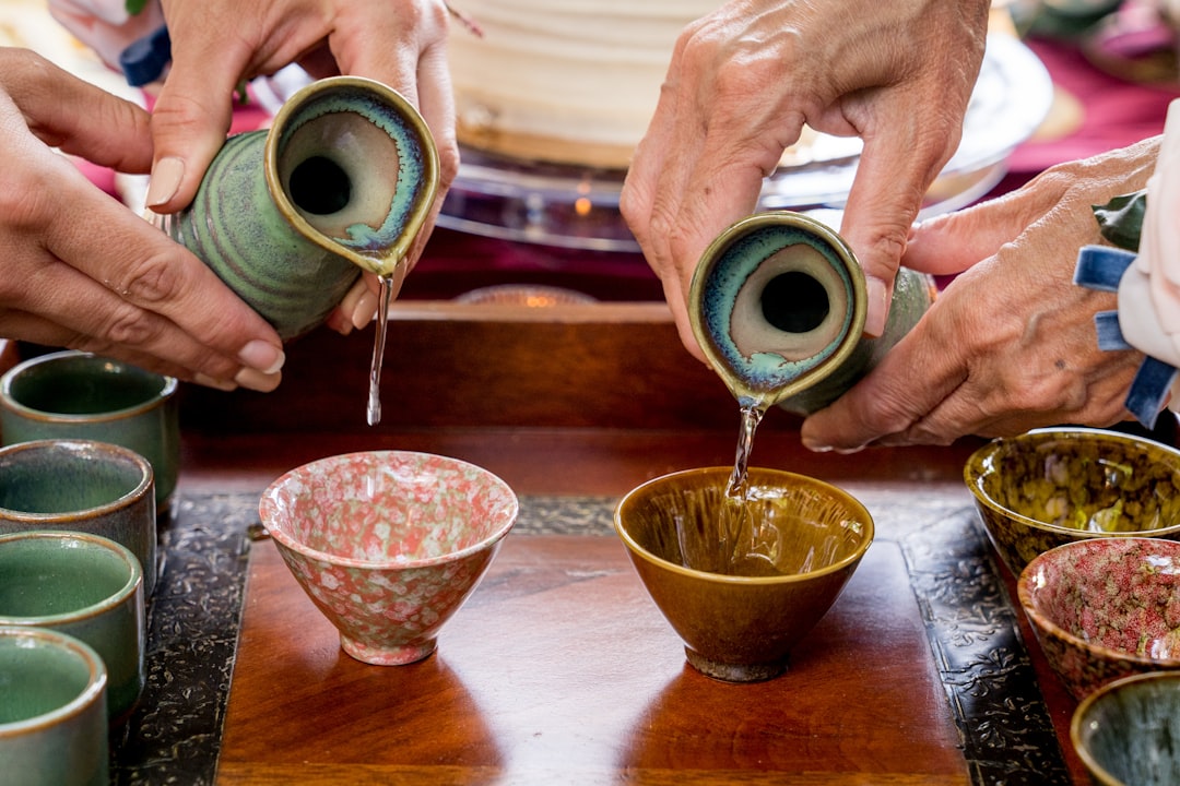 陶器の徳利からおちょこへ日本酒を注いでいる様子