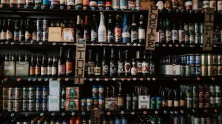 様々な種類のビール瓶が並んでいるイメージ